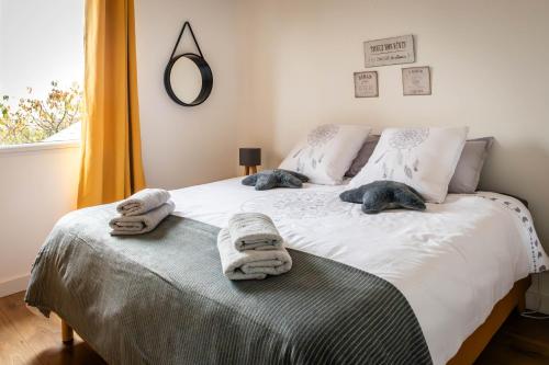 a bedroom with a bed with towels on it at Comme une evidence in La Chapelle aux Pies
