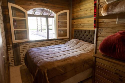 a bedroom with a bed in a room with a window at Cabana em Urubici Serra do Corvo Branco in Urubici