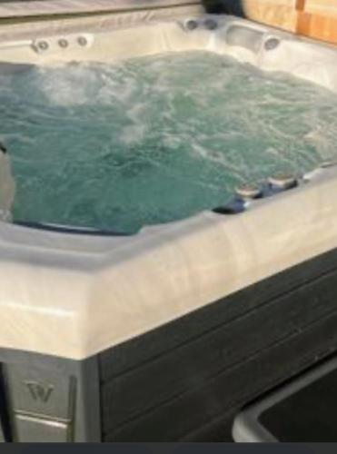 a hot tub with green water in it at Comme une evidence in La Chapelle aux Pies