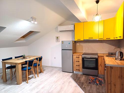 Una cocina con gabinetes amarillos y una mesa con sillas. en ML apartment, en Bitola