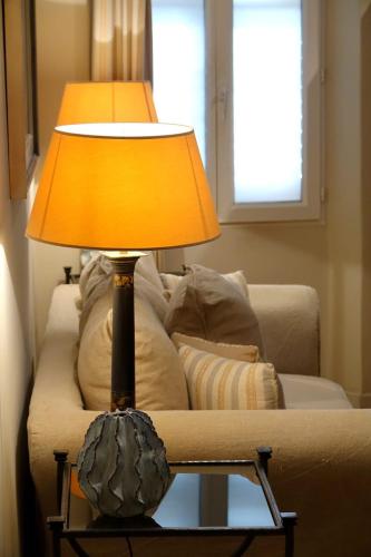une lampe posée sur une table devant un canapé dans l'établissement Beautiful T2 close to the beach, à Saint-Tropez