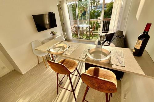 - une cuisine avec une table et 2 chaises ainsi qu'une bouteille de vin dans l'établissement One-bedr ap 50m from the beach terrace swimming pool air con, à Antibes