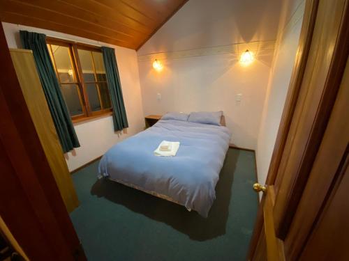 a small bed in a small room with a window at Oultan Homestead Farm Stay in Ikamatua