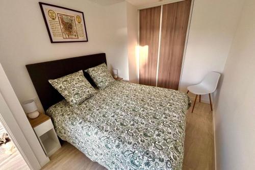 une petite chambre avec un lit et une chaise dans l'établissement One-bedr ap 50m from the beach terrace swimming pool air con, à Antibes