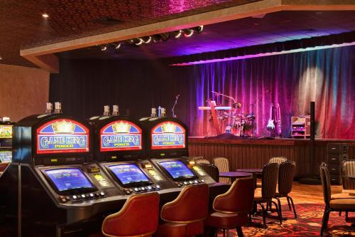 a row of slot machines in a room with a stage at Maverick Hotel and Casino by Red Lion Hotels in Elko
