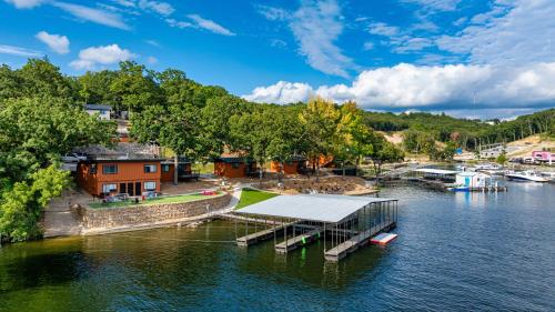 a dock on a river with houses and trees at Sunset Beach Resort in Osage Beach