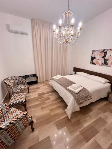 a bedroom with a bed and a chandelier at Grandmas holiday home Sicily in Giarre