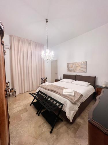 a bedroom with a large bed and a chandelier at Grandmas holiday home Sicily in Giarre