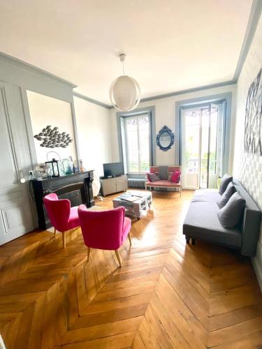a living room with a couch and red chairs at Chez Mo in Lyon