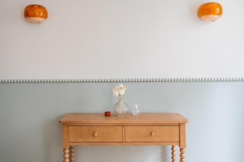 une table en bois avec un vase de fleurs dessus dans l'établissement Bubble House-Paris15-Mobility lease, à Paris