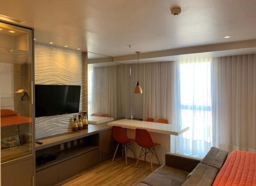 a room with a bed and a desk with a television at DF PLAZA aconchegante com vista in Águas Claras
