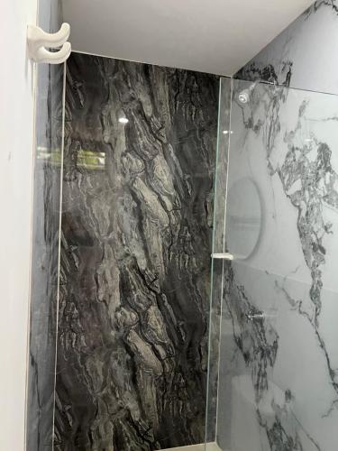 a bathroom with a black and white marble wall at Ancestral Casa de Campo in Roldanillo