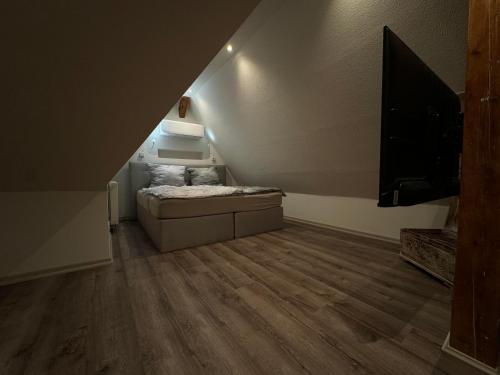 a room with a couch and a television in a attic at Klimaanlage, 5 Sterne Villa Bahnhoftraum, plus NEU zubuchbares Event, 333 qm, 1200qm Garten, virtueller Rundgang, Dachterrasse, Whirlpoolbadewanne in Braunfels