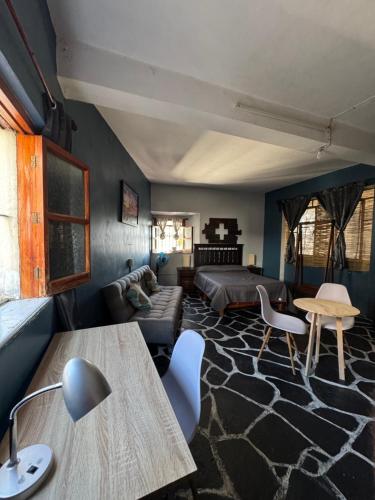 a living room with a bed and a table at Casa Paramar in Taxco de Alarcón