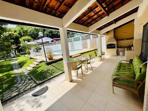 安格拉杜斯雷斯Casa em Angra com Piscina e Descida para Jet Ski的户外庭院配有沙发和桌椅。
