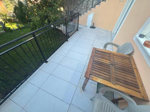 a wooden bench sitting on a balcony with a railing at Villa Miramare , Dobrota seafront in Kotor