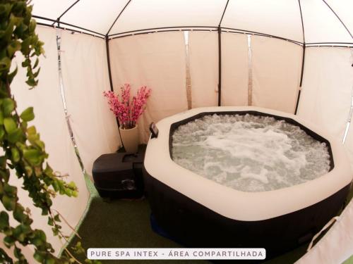 a bath tub in a tent with water in it at Castelinho Solemar - Apart Premium a Passos da Praia in Praia Grande