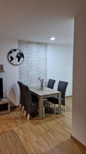 a dining room with a table and black chairs at Finans2 in Ruma