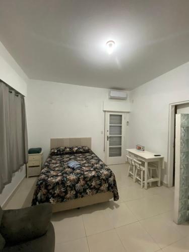 une chambre avec un lit et un bureau dans l'établissement Apto Santos Gonzaga 45 mtrs Praia, à Santos
