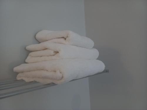 a stack of white towels sitting on a shelf at Cape Town Panorama Luxe Suite in Cape Town