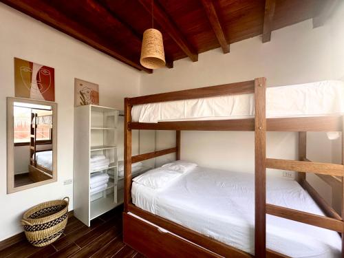 Un dormitorio con dos literas y un espejo. en Refugio del Mar Wakama, en San Vicente de Cañete