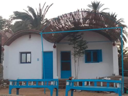 a building with two blue benches in front of it at Hannag Island in Aswan