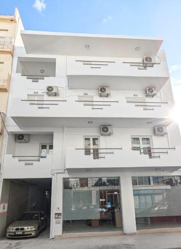 a white building with a car parked in it at Dimitris City Break Apts in Chania