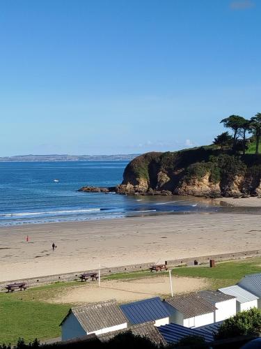 - une plage avec des gens sur le sable et l'océan dans l'établissement La Baie en direct du Balcon !, à Douarnenez