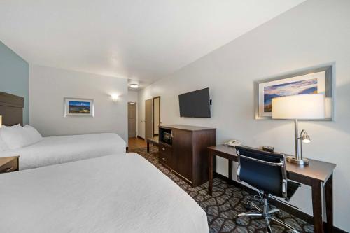 a hotel room with two beds and a desk and a television at Best Western Crater Lake Highway White City/Medford in White City