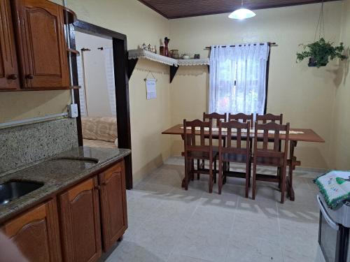 a kitchen with a dining room table and chairs at Caminhos da Serra do Tabuleiro - Casa Centenária Enxaimel 1915 in São Bonifácio