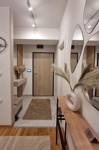 a hallway with a door and a vase on a table at Luxury Gold Apartment in Skopje