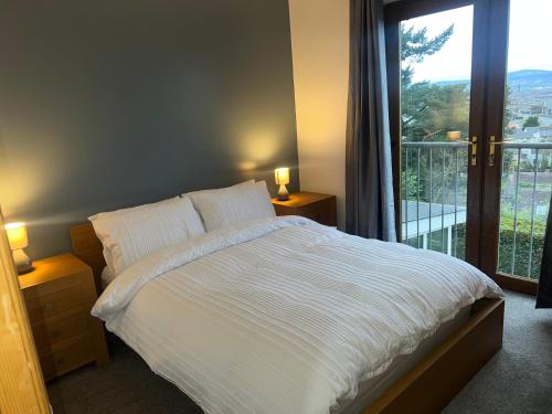 a bedroom with a bed and a large window at Castlereagh Belfast beauty in Belfast