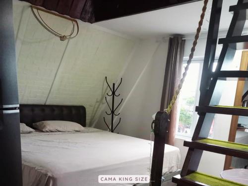 a bedroom with a bed and a ladder at Castelinho Solemar - Apart Premium a Passos da Praia in Praia Grande