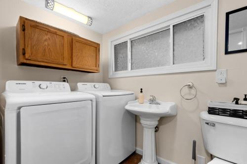 a white laundry room with a washer and a sink at Comfort Cabin - 2BD Family Getaway in Creve Coeur in Creve Coeur