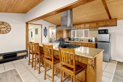 a kitchen with a large island with chairs in it at Comfort Cabin - 2BD Family Getaway in Creve Coeur in Creve Coeur