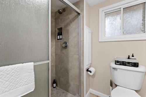 a bathroom with a shower with a toilet and a window at Comfort Cabin - 2BD Family Getaway in Creve Coeur in Creve Coeur