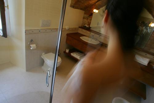 a woman is in a bathroom with a shower at La Locanda Di San Francesco in Montepulciano