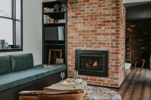 a living room with a fireplace and a couch at Braithwaite Hobart - Chic Retreat with Outdoor Bath in Hobart
