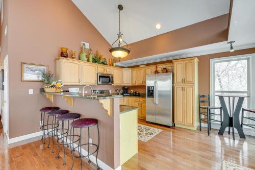 a kitchen with wooden cabinets and bar stools at 2 Mi to Ski Resort Beech Mtn Home with Fire Pit! in Beech Mountain