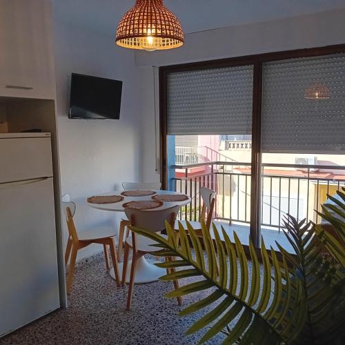 a kitchen with a table and chairs and a balcony at María PLAYA 1 NG in Peniscola