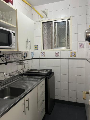 a small kitchen with a sink and a microwave at Corazón obelisco 3 in Buenos Aires