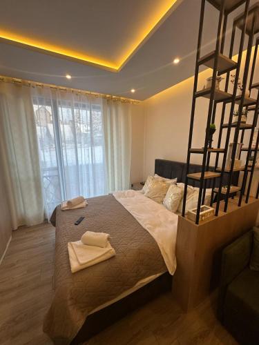 a bedroom with a large bed with two towels on it at Apartman B64 Residence Hill Kopaonik in Kopaonik