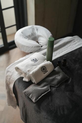 a bed with towels and a green candle on it at Rodona Hotel in Mexico City