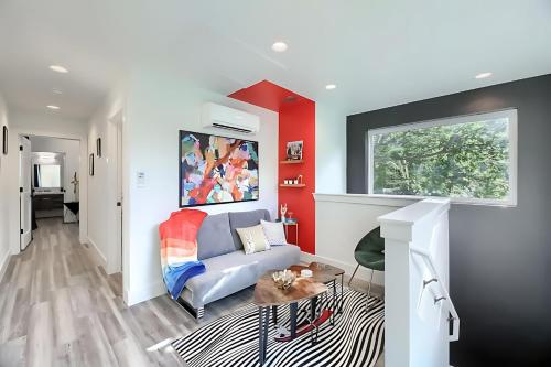 a living room with a couch and a red wall at East Side 3BR Masterpiece Home in Austin