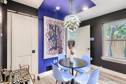 a dining room with blue walls and a table and chairs at Stylish 3BR East Side Retreat w Patio & BBQ in Austin
