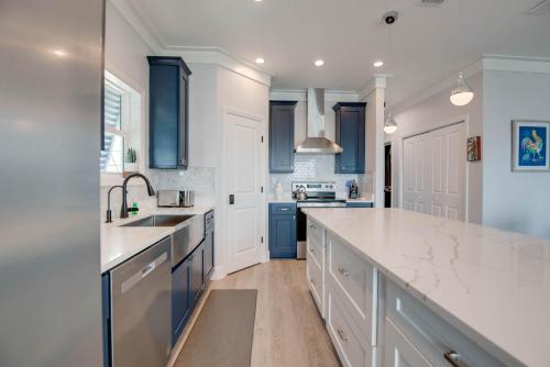 a kitchen with white counters and blue cabinets at Ritaville - Monthly Rental in Stock Island