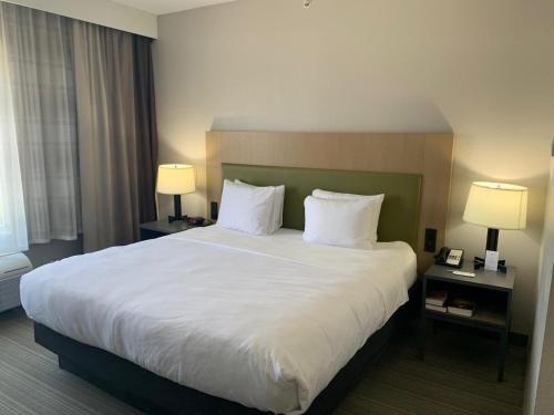 a large bed in a hotel room with two lamps at Country Inn & Suites by Radisson, Austin North Pflugerville , TX in Round Rock