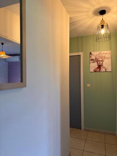 a hallway with a painting on the wall and a light fixture at Effet Plage in Quartiers Anse à lʼÂne