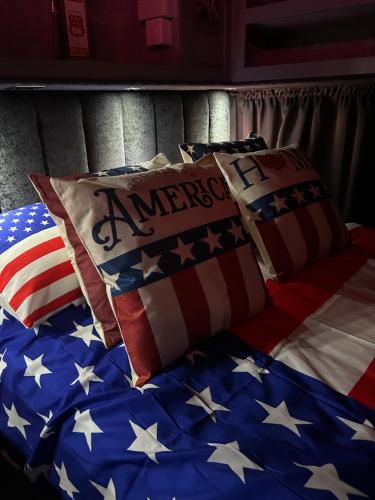 a bed with an american flag pillows on it at American rv glamping with hot tub in St Asaph