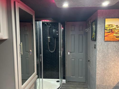 a bathroom with a shower with a glass door at American rv glamping with hot tub in St Asaph